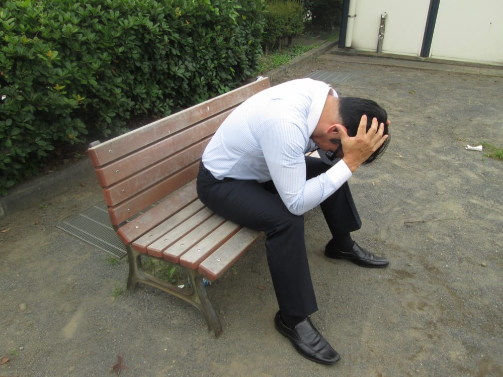 頭を抱え込む男性